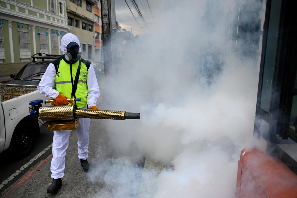 Kakitangan pihak berkuasa menyembur asap untuk mengekang pembiakan nyamuk Aedes. - FOTO AFP