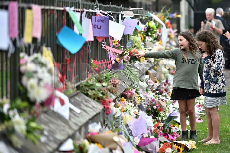 ORANG ramai meletak kalungan bunga memperingati serangan pengganas di Christchurch, semalam. FOTO AFP 