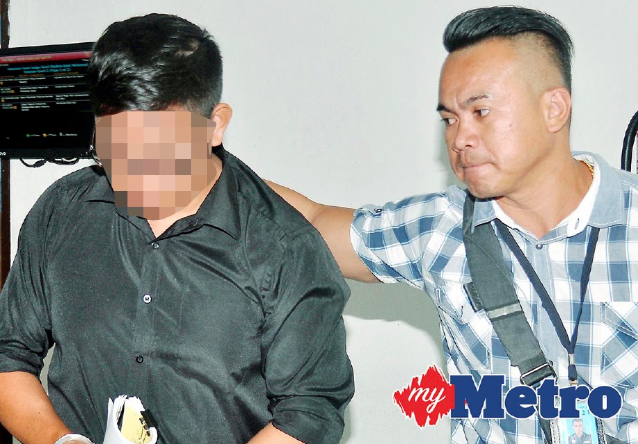 ANGGOTA polis mengiringi Agoes selepas mengaku tidak bersalah atas kesalahan seksual terhadap seorang remaja lelaki berumur 15 tahun, di Mahkamah Sesyen Kota Kinabalu. -Foto MOHD ADAM ARININ
