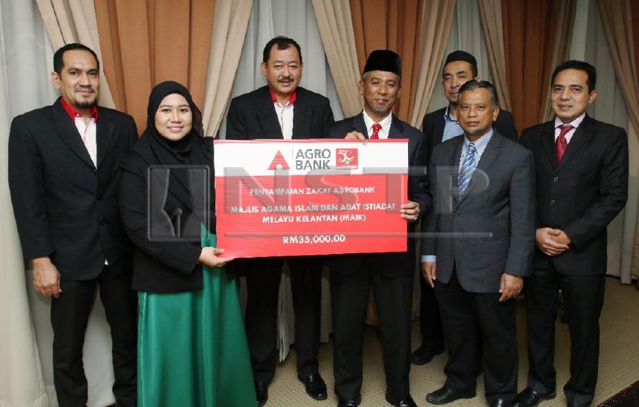 NIK Mohd Azlan (tiga kanan) menerima cek zakat  perniagaan bernilai RM35,000 daripada Agrobank. FOTO Nik Abdullah Nik Omar