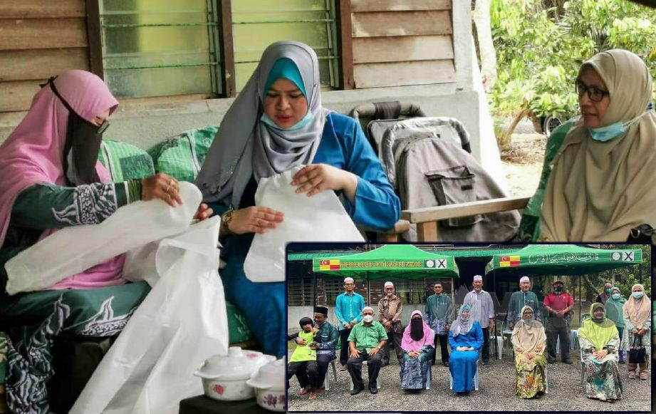 Menteri Pembangunan Wanita, Keluarga dan Masyarakat Datuk Seri Rina Mohd Harun melihat pakaian Peralatan Perlindungan Diri (PPE) ketika kunjungan terhadap sukarelawan Dewan Muslimat PAS, Sepang, Selangor, semalam.