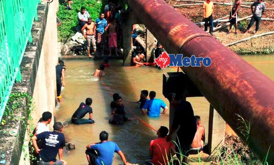 Orang ramai membantu mencari mangsa lemas di sungai di Kampung Batu Hitam, Gaal, Pasir Puteh. FOTO ihsan pembaca