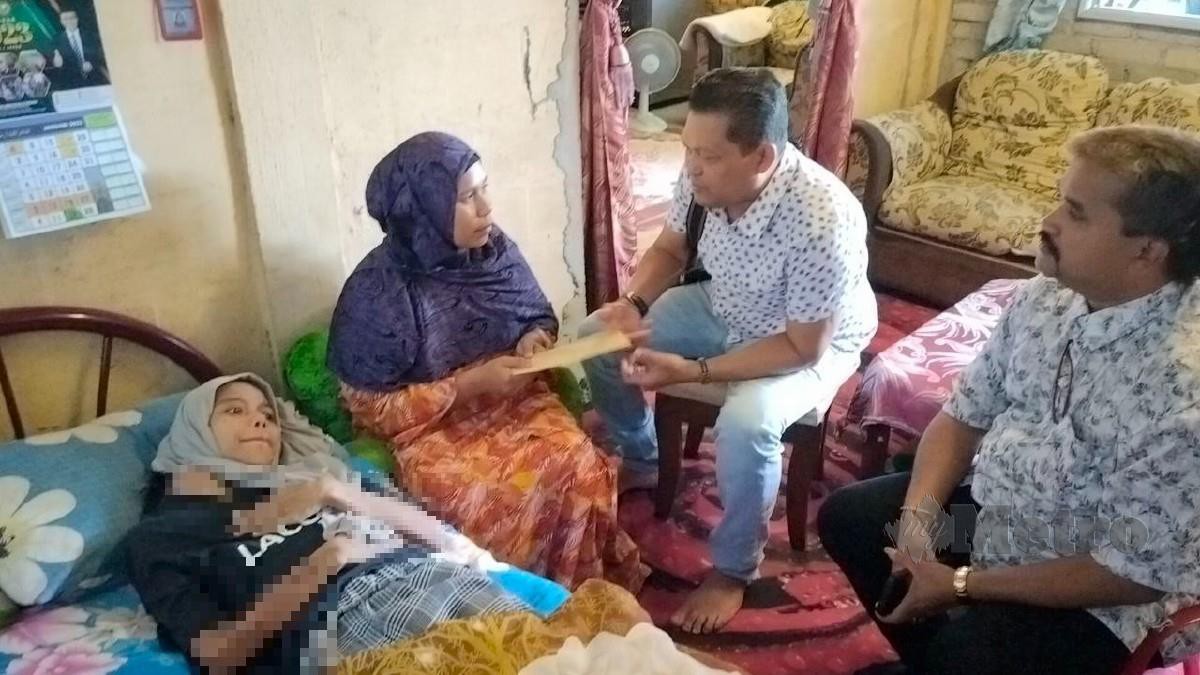 KASTURI menyampaikan sumbangan kepada Aida Harita untuk membiayai kos rawatan Nur Aifa Shamimi yang menghidap kanser sel di rumah mereka di Taman Kota Nelayan, Kuala Kedah. FOTO Zuliaty Zulkiffli