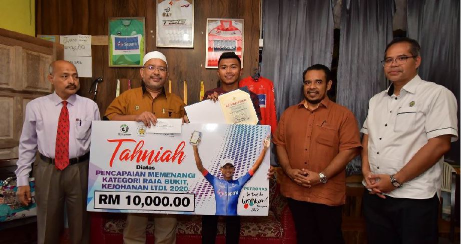 MUHAMMAD Nur Aiman  menerima sumbangan daripada Wan Sukairi. FOTO MSNT