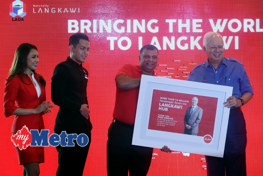 Najib menerima cenderahati Tony (dua dari kanan) selepas majlis perasmian penerbangan AirAsia Langkawi-Shenzen China. FOTO Amran Hamid 