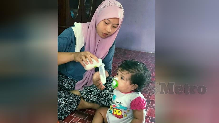 SITI Noradila memberi Nur Shazia Airis minum susu melalui tiub yang dipasang di hidungnya. FOTO Hazira Ahmad Zaidi.