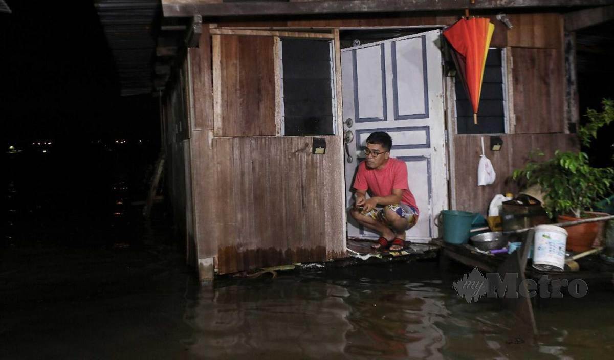 WAN Mohd Adlan termenung di rumahnya berikutan fenomena air pasang besar melanda Kampung Losong Haji Mohd. FOTO Ghazali Kori
