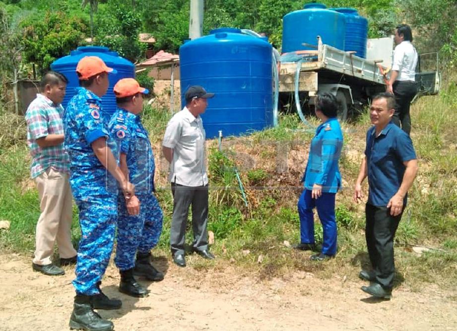 ANGGOTA Angkatan Pertahanan Awam Malaysia (APM) dan Pegawai Daerah Tuaran, Mohd Sofian Alfian Nair (tengah) memantau masalah air dan menyalur bantuan bekalan air di Kampung Ulu Bakut, Tuaran. 