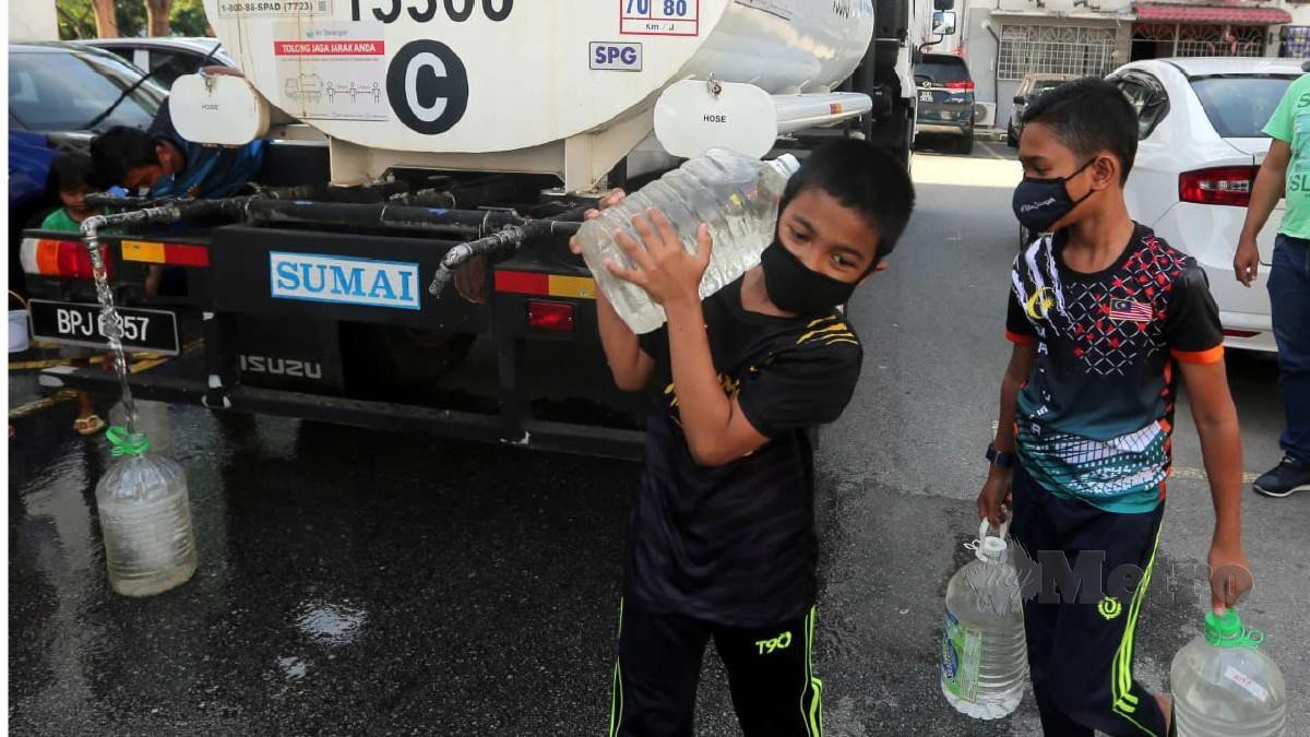 PENDUDUK di Flat Taman Bunga Negara, Seksyen 27, Shah Alam mengambil air dari lori tangki Air Selangor susulan gangguan bekalan air, hari ini. FOTO MUHD ASYRAF SAWAL