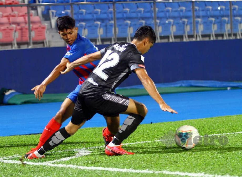 Pemain Kelantan, Mohamad Hakami Abdullah (kanan) cuba menghalang pemain JDT II pada aksi Liga Perdana. FOTO Zain Ahmed