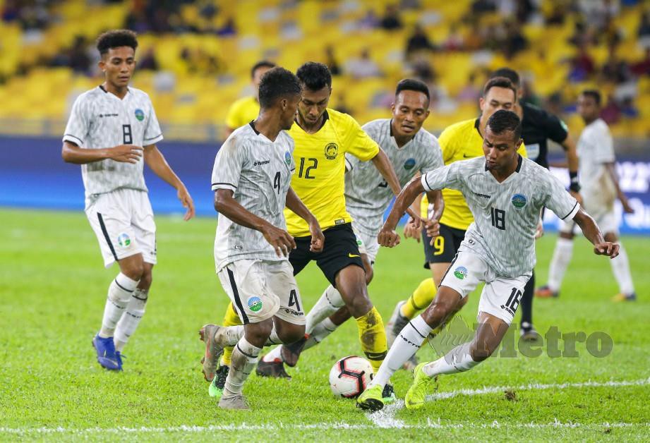 AKRAM (tiga kiri) diasak pemain Timor Leste pada aksi playoff Piala Dunia 2022/Piala Asia 2023 di Bukit Jalil. — FOTO Aziah Azmee