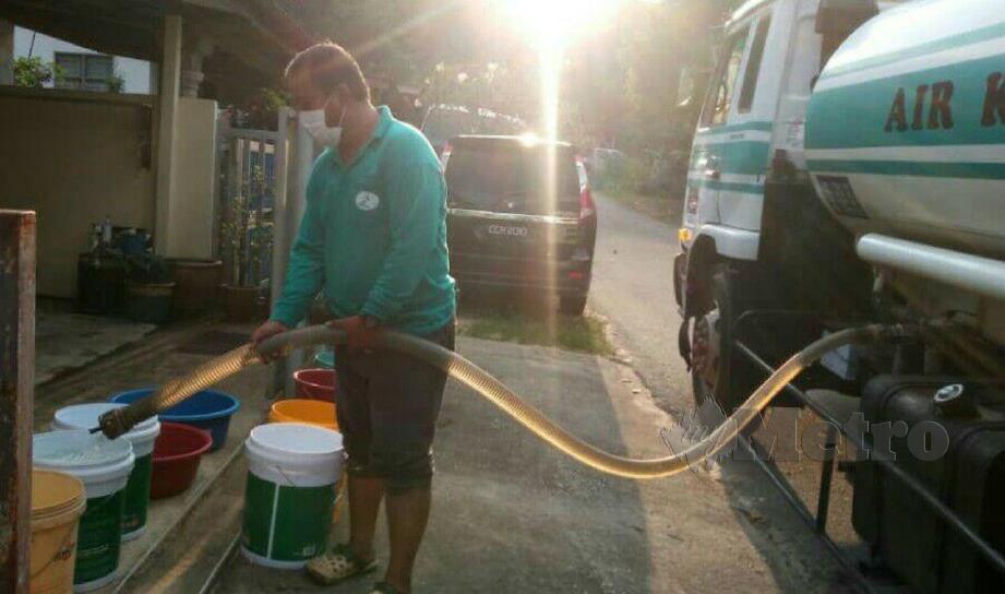 KAKITANGAN AKSB menghantar bekalan air bersih kepada penduduk Taman Tropika, Gua Musang dengan menggunakan lori tangki, semalam. FOTO RAMLI IBRAHIM