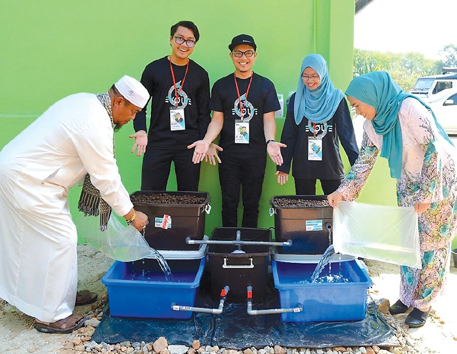 NAZMI  dan Dr Mohd Istajib (tengah) semasa sesi pelepasan ikan ke dalam sistem akuponik. FOTO NSTP