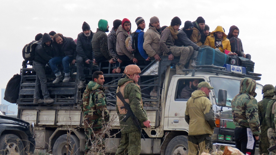 Tentera Syria mengawasi orang ramai dan pemberontak yang meninggalkan Alleppo pada hari kedua operasi mengosongkan bandar raya kedua terbesar Syria itu. - Foto AFP