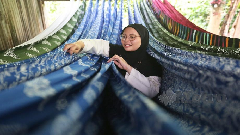 Haniza melihat batik terap yang dihasilkan di Bengkel Batik Nysa Kapas dekat rumahnya di Kampung Serada, Kuala Terengganu. Foto Ghazali Kori   