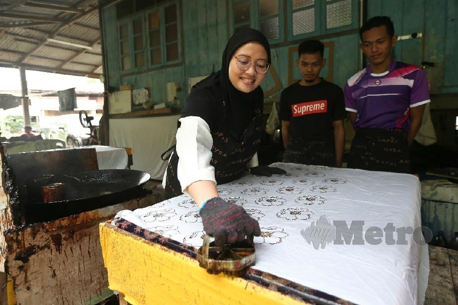 Haniza menunjukkan cara melakukan kerja mengecop batik kepada pekerja di Bengkel Batik Nysa Kapas dekat rumahnya di Kampung Serada, Kuala Terengganu. Foto Ghazali Kori   