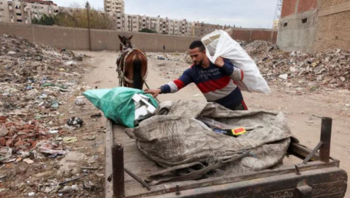 SHARKAWI gigih bekerja di pusat pungutan sampah. FOTO Reuters