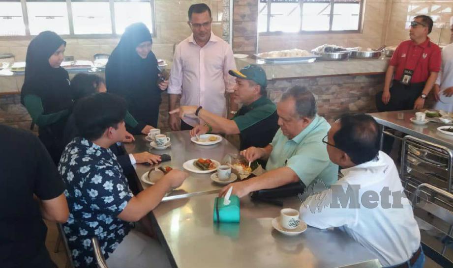 NADZIM (duduk tiga dari kanan) berbual dengan Ali (berdiri tiga dari kiri) serta pelanggan di Restoran Ali Cafe Tomyam di Jalan Pantai Baharu, Kuala Lumpur, hari ini. - FOTO Yusmizal Dolah Aling. 