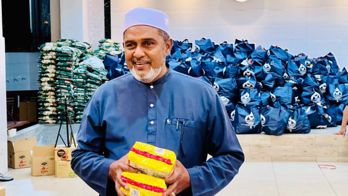 JAWAHAR Ali bersama beras dan barangan lain yang disumbangkan kepada asnaf dan golongan memerlukan. FOTO Ihsan pembaca.