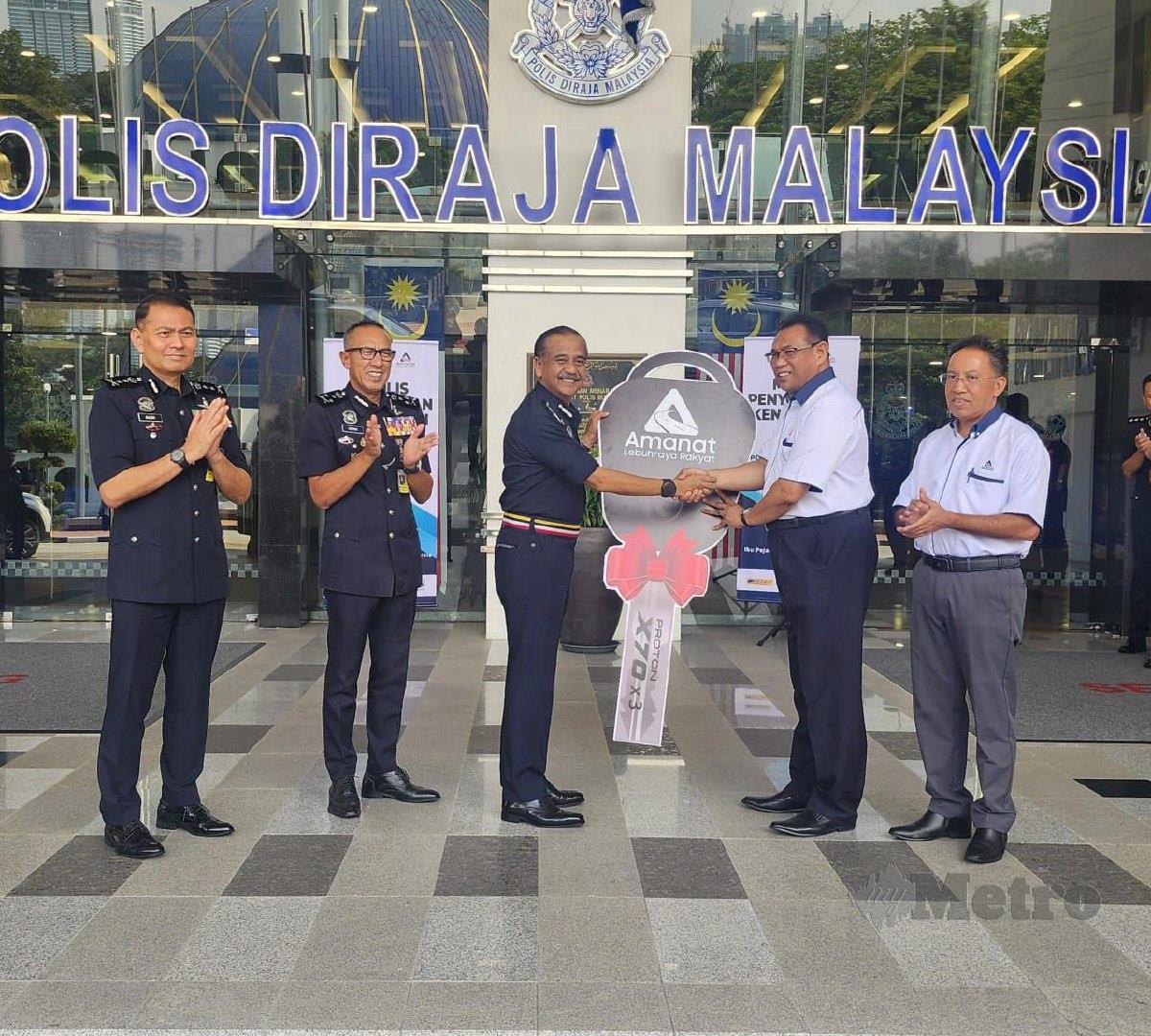 SAZALLY (dua kanan) menyampaikan replika kunci Proton X70 kepada Razaruddin di Ibu Pejabat Polis Bukit Aman, semalam, sebagai simbolik penyerahan tiga unit kenderaan itu kepada PDRM bagi mempertingkatkan tahap pemantauan trafik dan keselamatan pengguna di lebuh raya di bawah kendalian Kumpulan ALR di Lembah Klang. FOTO ihsan ALR