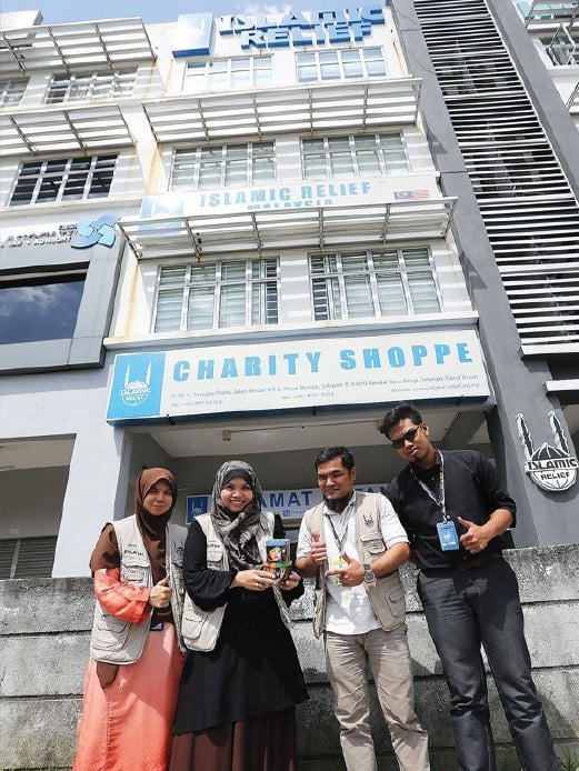 SITI Fadilah (dua dari kanan) bersama kakitangan IRM di depan ibu pejabat IRM dan Charity Shoppe.