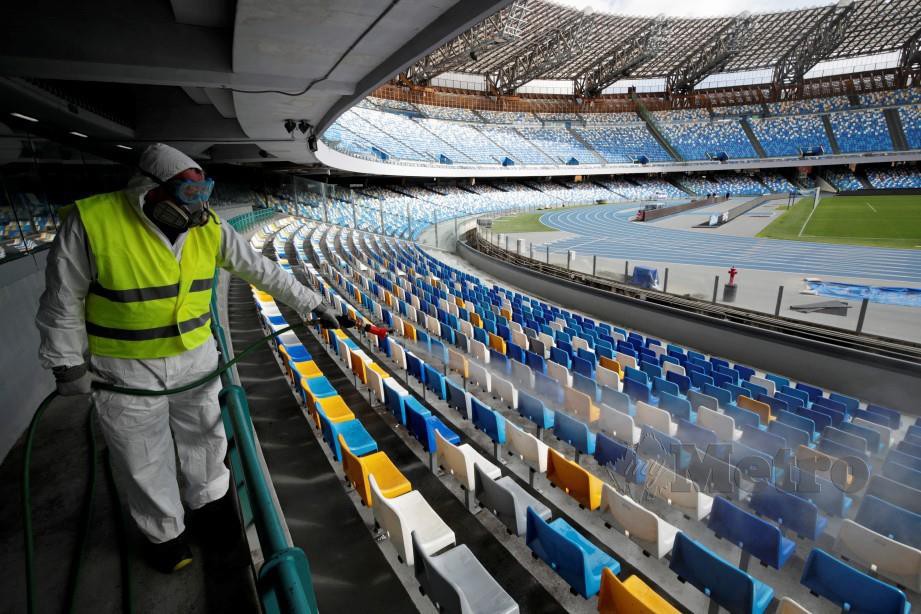 Seorang pekerja membersihkan Stadium San Paolo di Itali. FOTO Reuters