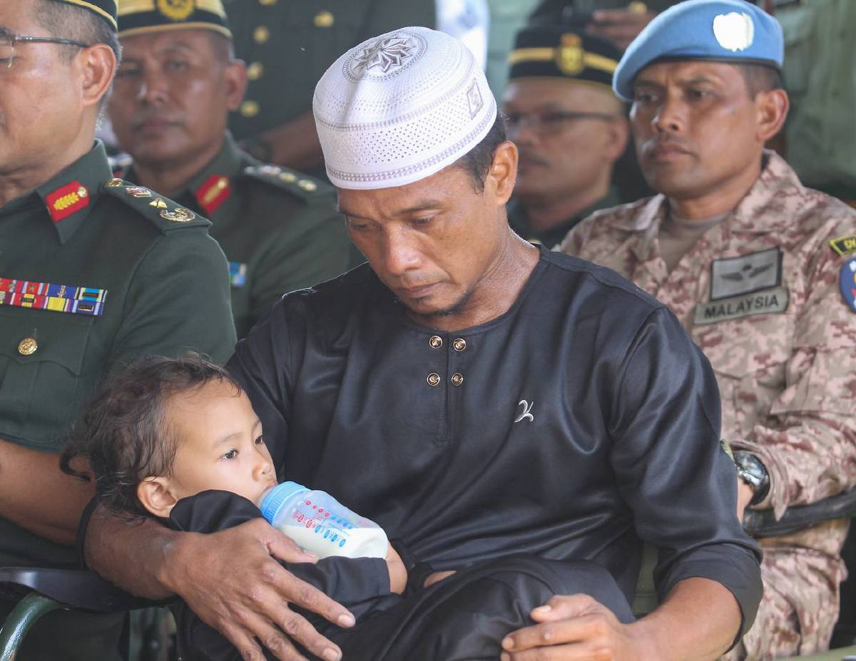 NOOR Azmi  bersama anaknya Ainul Mardiah, di Tanah Perkuburan Islam Masjid Al Anwar Kampung Tengah. FOTO Wan Nabil Nasir.