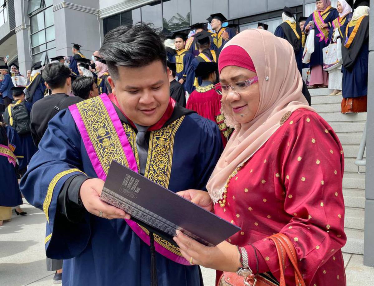 Wan Amirul Aizzat menunjukkan Anugerah Naib Canselor, kelas pertama kepada ibunya, Khairizan Sabtu. FOTO Ihsan UiTM Shah Alam