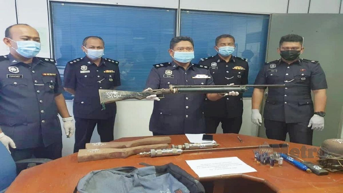 Baharudin (tengah) menunjukkan senapang angin yang dirampas. FOTO Rosli Ilham 