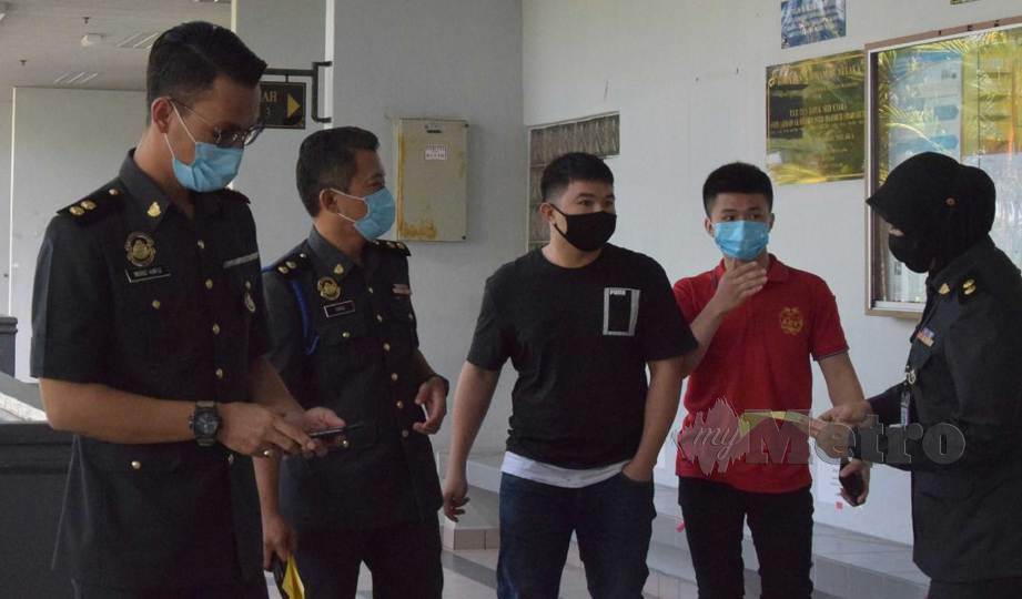 TERTUDUH, Teo Wei Chiang (dua kanan) dan Teo Fang Hao (tengah) didakwa di Mahkamah Sesyen Ayer Keroh atas tuduhan menjual minyak angin tiruan. FOTO Amir Mamat