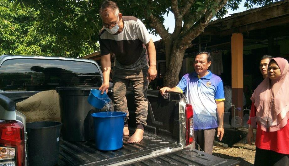 PENDUDUK Taman Tropika, Gua Musang mengharapkan ihsan jiran yang ada kenderaan pacuan empat roda untuk mengangkut air bersih dari kampung berhampiran terutama untuk memasak. FOTO RAMLI IBRAHIM