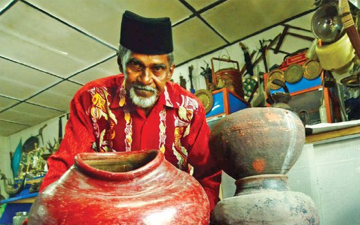 MOHD ALI menunjukkan tempayan 'mulut senget ' yang ukirannya tidak seperti mulut tempayan biasa berusia kira-kira 400 tahun dibeli di Terengganu.