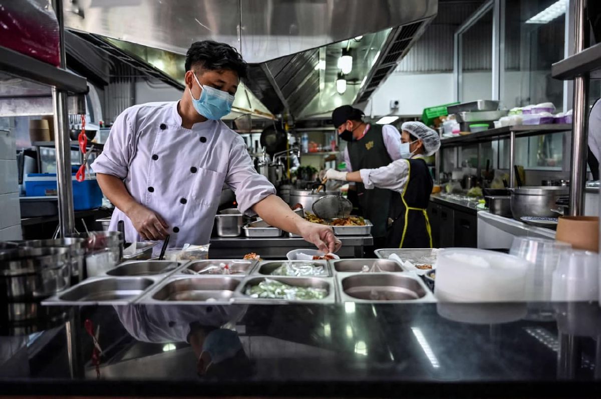 KAKITANGAN dapur awan di Bangkok menyediakan makanan yang dipesan pelanggan. FOTO AFP