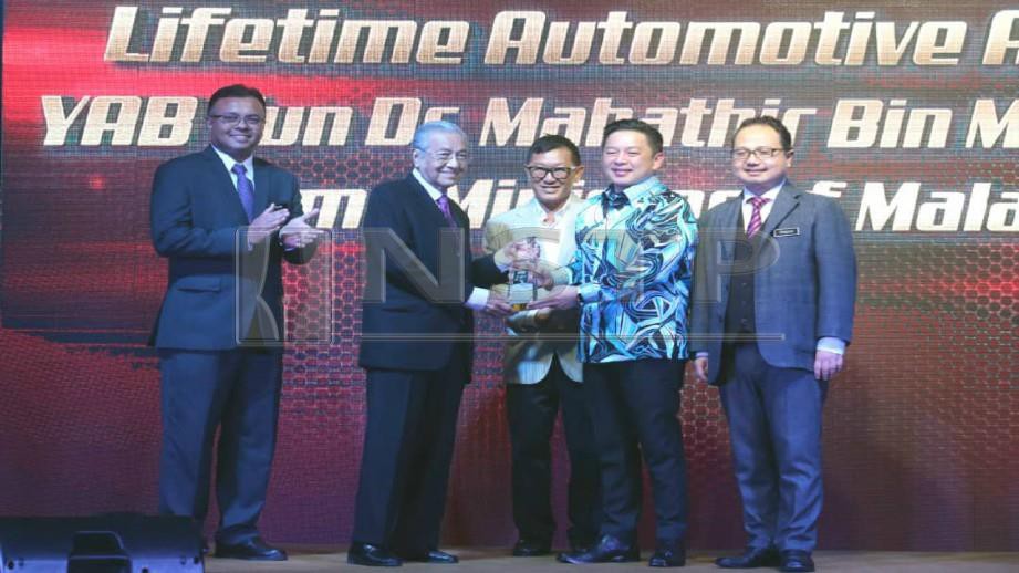 DR Mahathir menerima Anugerah Automotif Sepanjang Hayat daripada Darell (dua kanan), hari ini. Foto EIZAIRI SHAMSUDIN