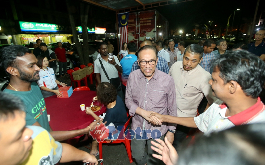 Anwar (tengah) bersalaman dengan orang ramai pada majlis makan malam bersama komuniti Cina yang diadakan di Tapak Letak Kereta PJS 8/7, Petaling Jaya. FOTO Mohd Khairul Helmy Mohd Din