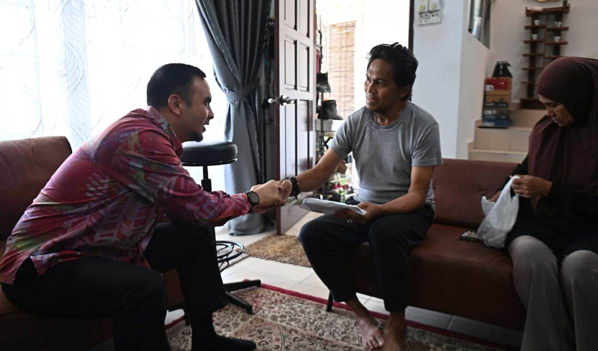 AHMAD Farhan (kiri) menghulurkan sumbangan kepada Mohd Ali yang menderita masalah paru-paru. FOTO Facebook Anwar Ibrahim