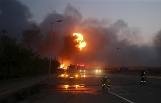 Api yang menjulang tinggi boleh dilihat sejauh beberapa kilometer selepas beberapa letupan dari gudang di pelabuhan di Tianjin, tengah malam tadi. - Foto Reuters