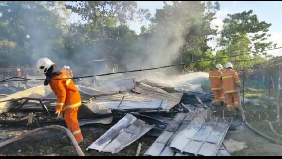 ANGGOTA bomba memadam kebakaran enam rumah kongsi di projek pembinaan Hospital Dungun di Jalan Pak Sabah, Dungun, hari ini. FOTO ROSLI ILHAM