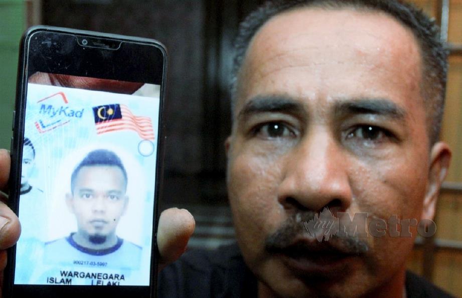 MOHD NASIR Mohd Yusof, 48, menunjukkan gambar anak saudaranya Sharil Apipie Mokhtar, 29. FOTO Nik Abdullah Nik Omar.