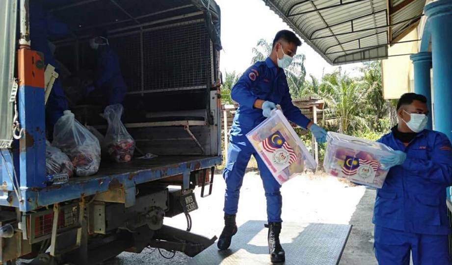 ANGGOTA Angkatan Pertahanan Awam Malaysia (APM) menyusun kit keperluan makanan penduduk terjejas Perintah Kawalan Pergerakan Diperketatkan (PKPD) di Simpang Renggam, sebelum agihan dilakukan petugas khas di kawasan zon merah. FOTO Ihsan APM