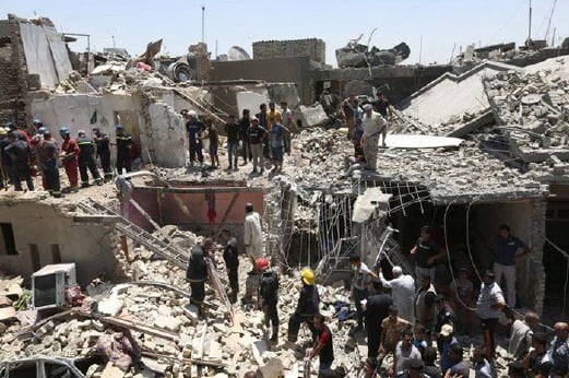 Anggota pasukan keselamatan Iraq dan orang ramai berusaha mencari mangsa yang terselamat selepas tiga rumah musnah akibat letupan bom yang jatuh dari pesawat penggempur Iraq. - Foto AP