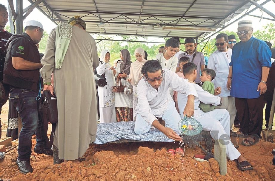 KHIR Rahman (tengah) menyiram air mawar di kubur arwah ayahanda Datuk A. Rahman Hassan di tanah perkuburan Taman Keramat. FOTO: Khairul Azhar Ahmad