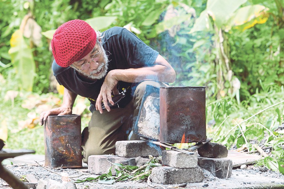 PAK Aris menerangkan proses membakar arang lukisan secara tradisional.
