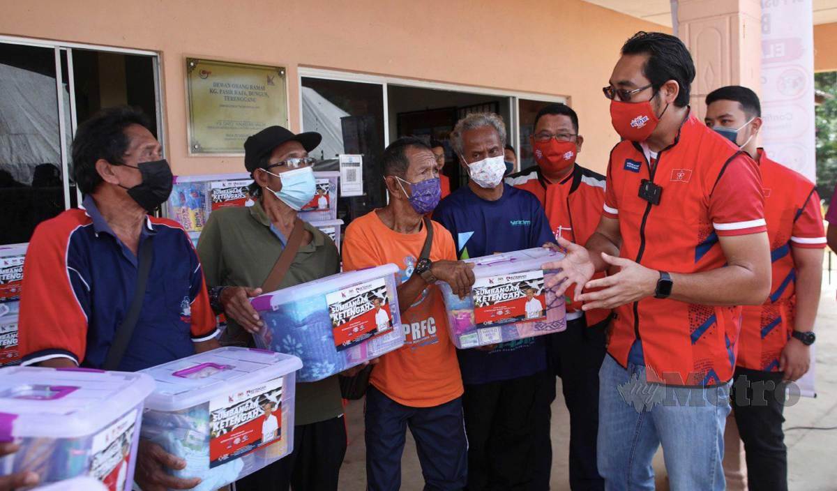 WAN Ahmad Fayhsal (kanan) beramah mesra bersama penduduk selepas menyampaikan bantuan kepada mangsa banjir di Kampung Pasir Raja. FOTO Ghazali Kori