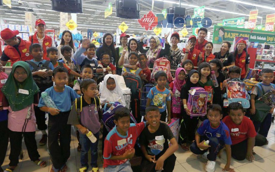 Aeron (barisan belakang, enam dari kanan) bersama kakitangan Forest City bergambar anak-anak Orang Asli ketika Program Kembali ke Sekolah 2018 di Pasaraya Giant Tampoi. FOTO HAIRUL ANUAR RAHIM