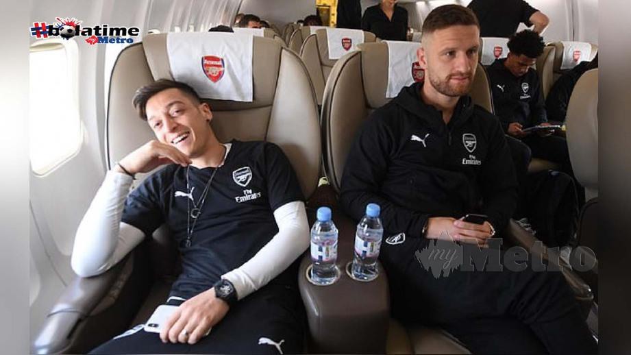 Ozil (kiri) bersama rakan sepasukan dalam pesawat. FOTO Arsenal FC