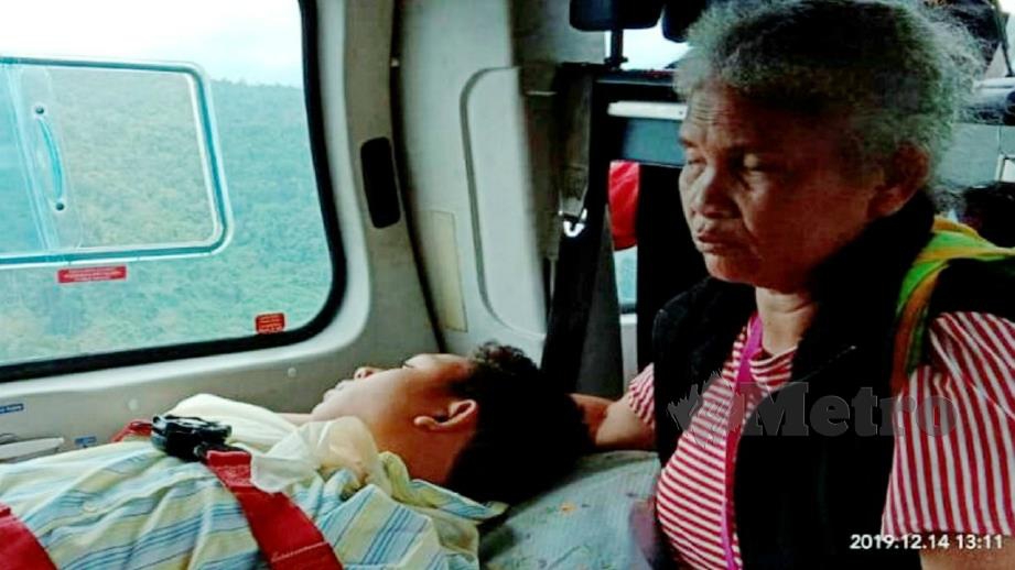 Seli dan ibunya ketika dalam helikopter untuk dibawa ke BBP Gua Musang sebelum dikejarkan ke HGM bagi mendapatkan rawatan hari ini. Foto Ihsan JBPM