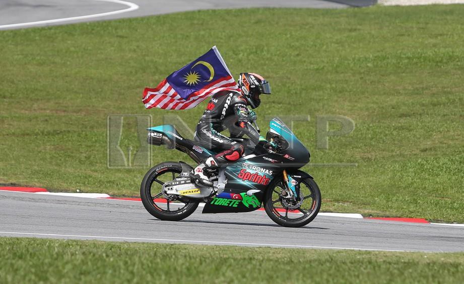 ADAM menerima bendera bersempena dengan perlumbaan terakhir beliau di Perlumbaan Moto3 pada MotoGP 2018 di Litar Sepang. -Foto NUR ADIBAH AHMAD IZAM