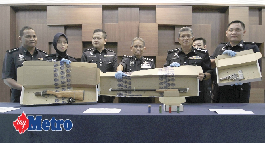 Mohd Asri (dua dari kanan) bersama Ketua Jabatan Siasatan Jenayah Kedah, Datuk Mohd Nashir Ya (tiga dari kanan) menunjukkan senapang semi auto dan sepucuk pistol di sini. FOTO Sharul Hafiz Zam 