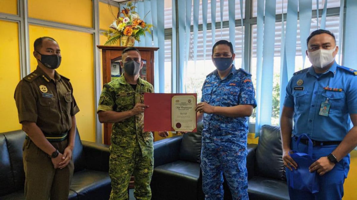 Mohd Rosman menyerahkan Sijil Perhargaan 'HERO' APM kepada Aswadi. FOTO IHSAN APM